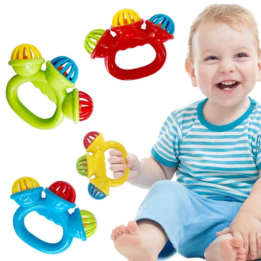 Happy baby with a set of four colorful, easy-grip plastic rattles in red, green, yellow, and blue.