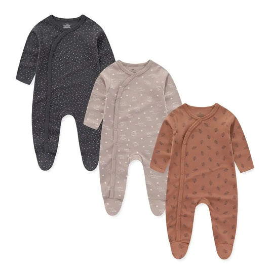 Three long-sleeve cotton baby rompers: charcoal with white dots, beige with stars, and rust with leaves.