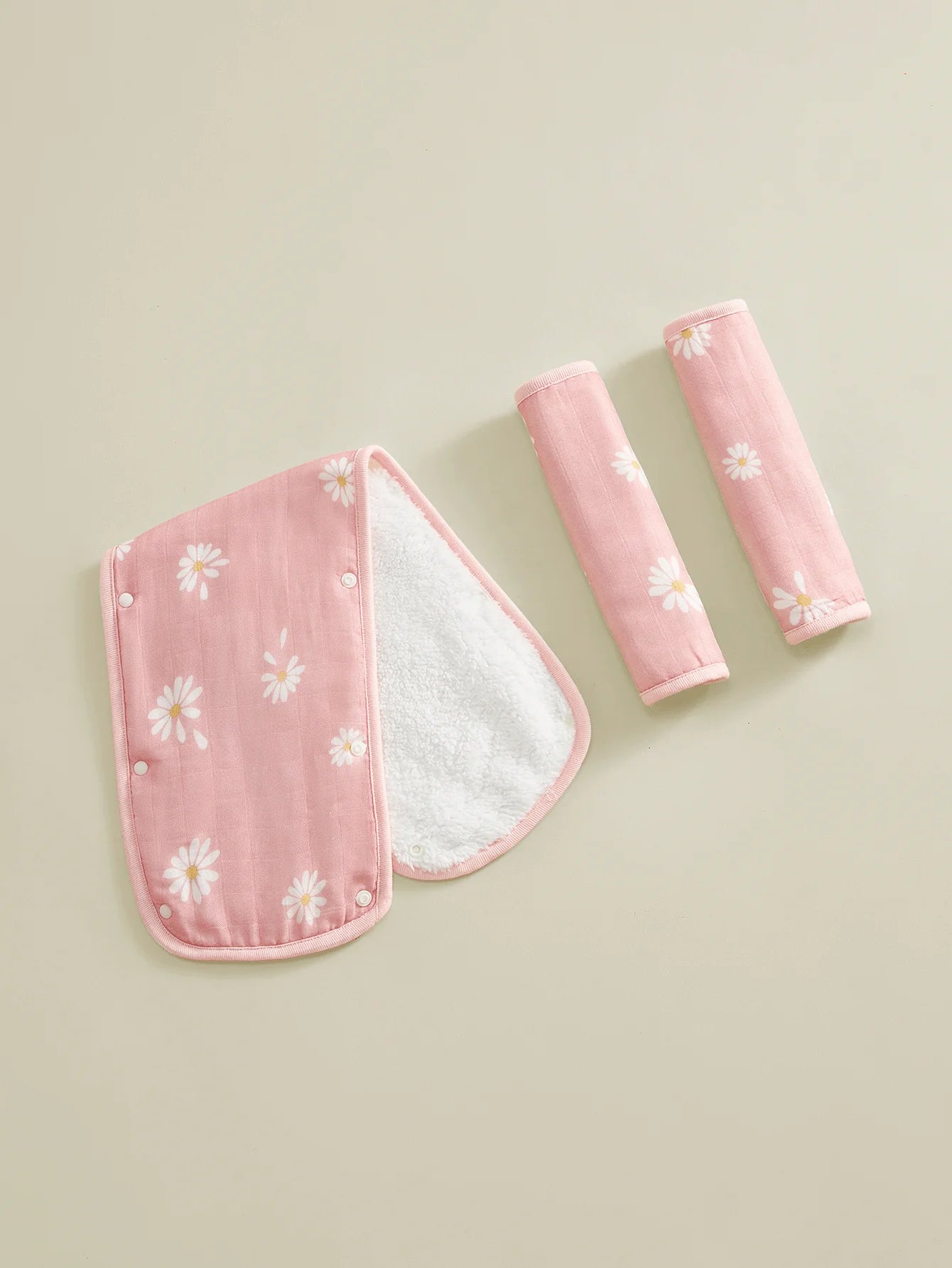 Pink daisy-print stroller handle cover and two matching safety belt pads with soft white lining.