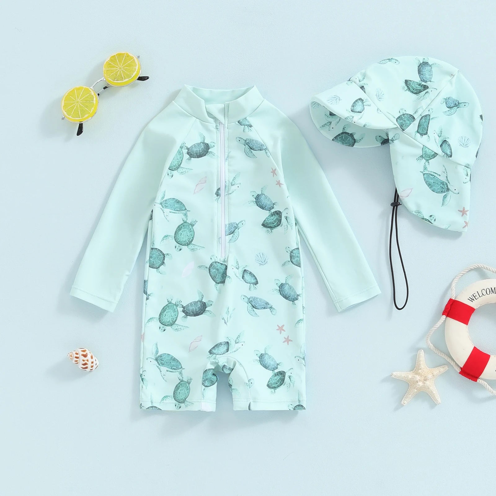 Mint green long-sleeve baby swimsuit with turtle print and matching sun hat.
