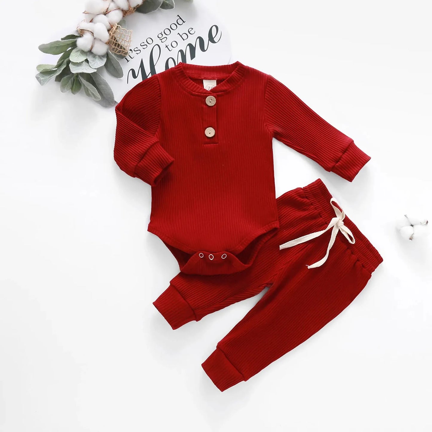 Red ribbed cotton long-sleeve baby bodysuit and matching pants with drawstring waist.