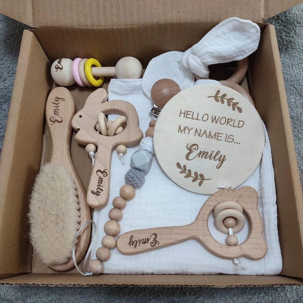 Personalized 8-piece natural wood baby gift set with brush, rattles, pacifier clip, and "Hello World" sign.