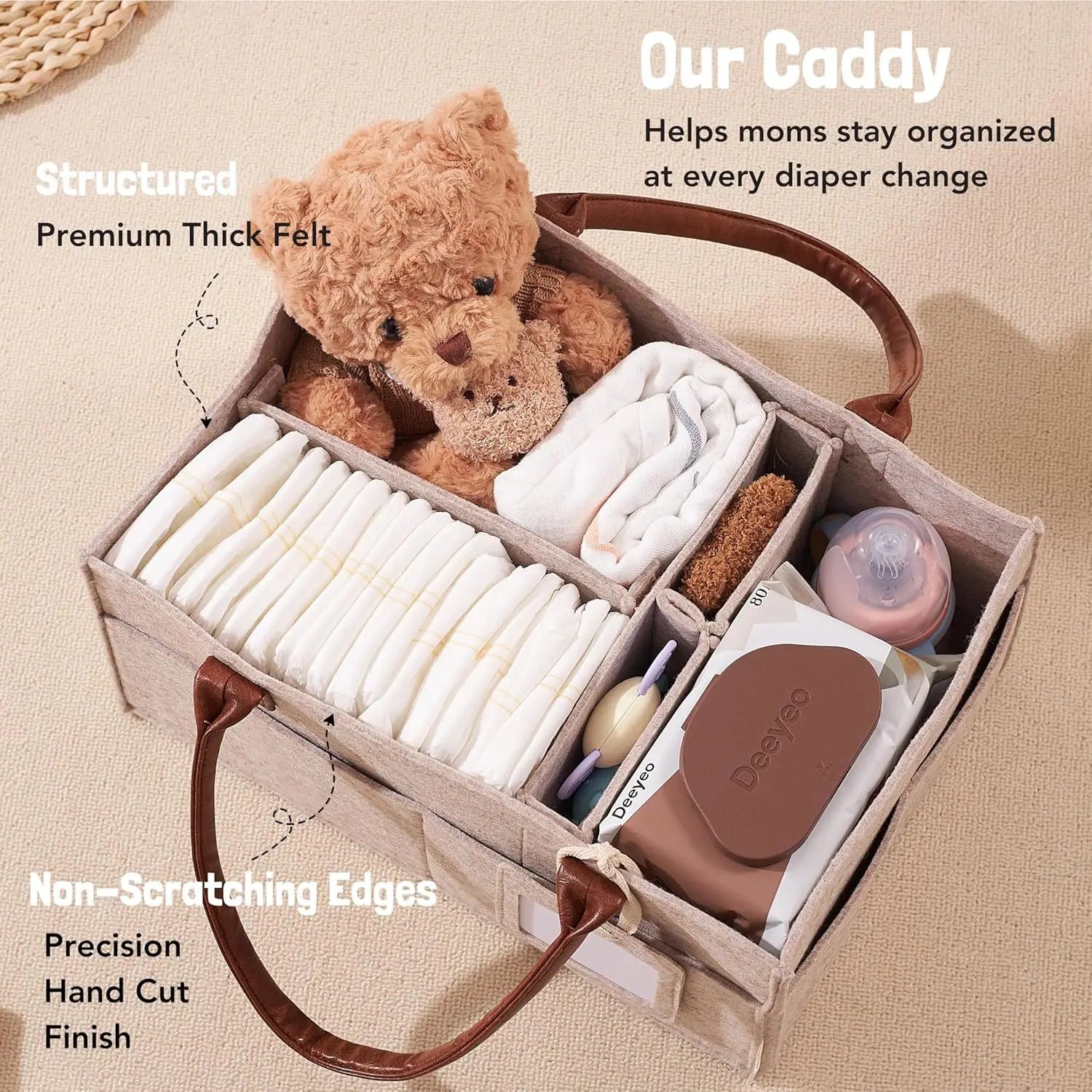 Beige felt diaper caddy with brown leather handles, organized with diapers, wipes, bottles, and a teddy bear.
