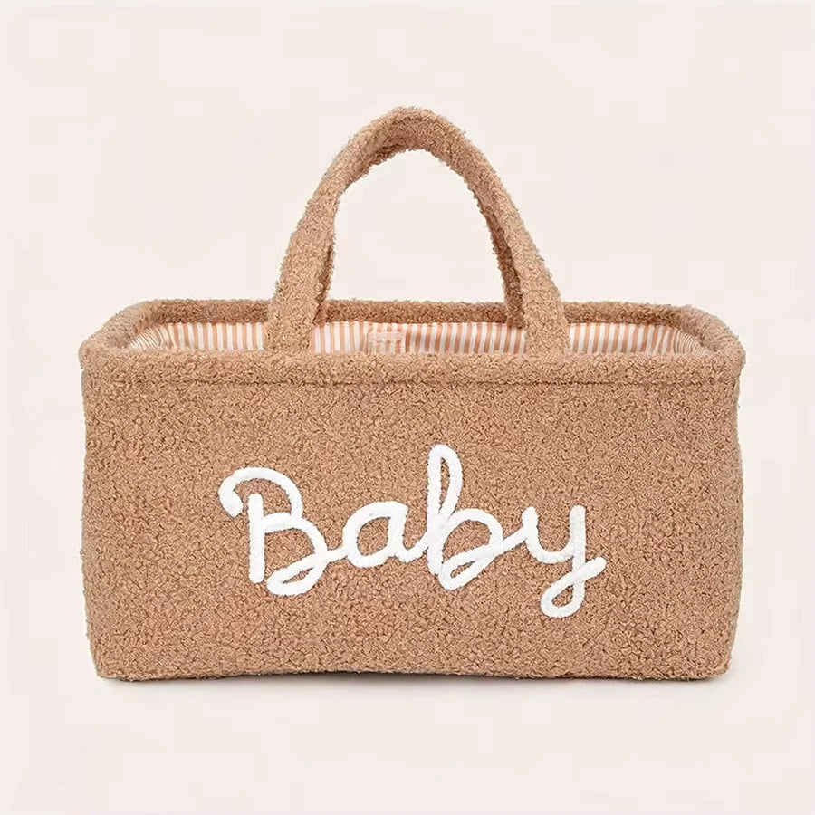 Brown plush fleece baby diaper caddy with "Baby" embroidered in white, striped lining, and soft handles.