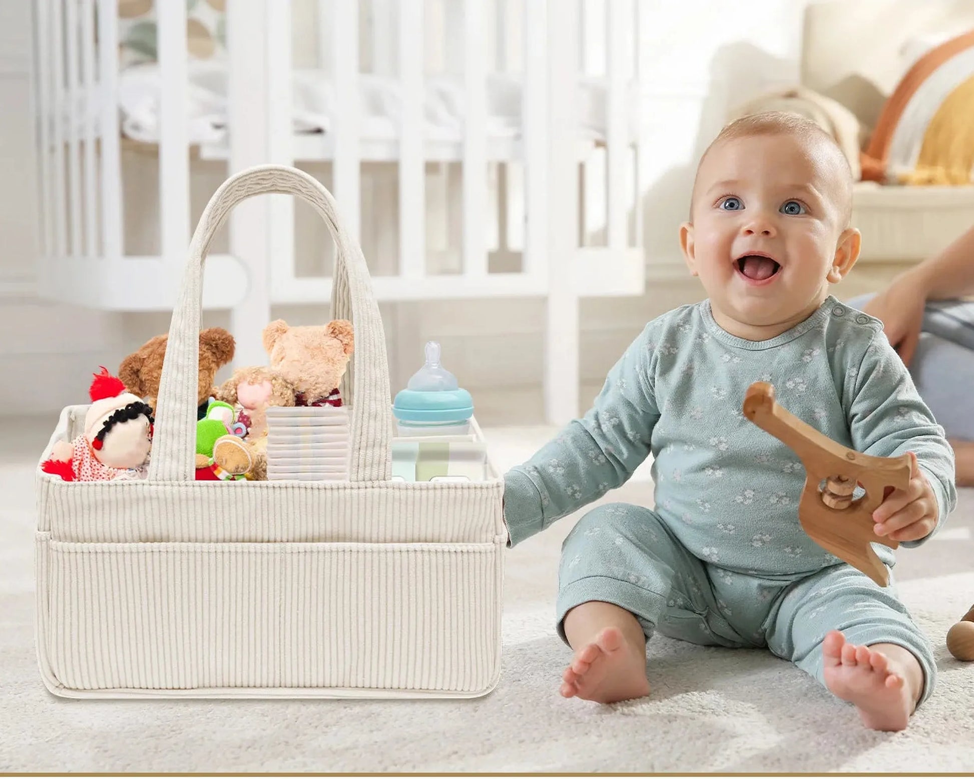 Beige corduroy and felt diaper caddy with handles, filled with baby items, next to a smiling baby.