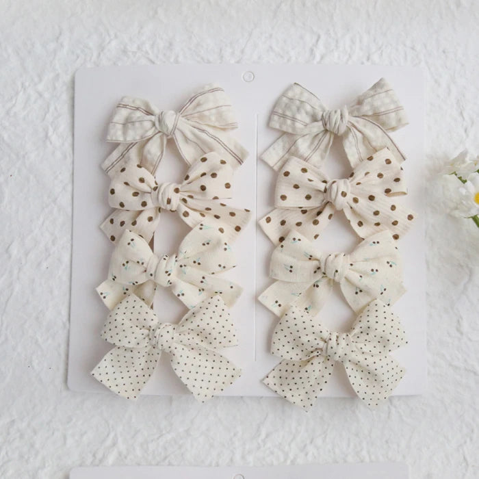 Set of 6 elegant cotton hair bows for girls in cream, white, and beige with polka dots and stripes.