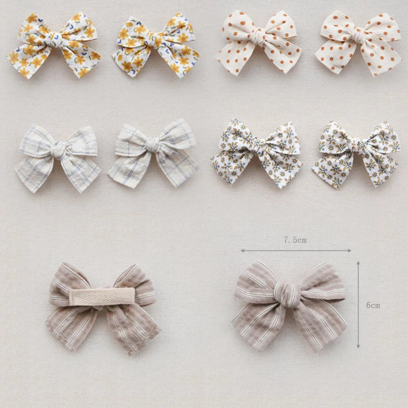 Collection of cotton hair bows for girls in various floral, polka dot, and plaid patterns.