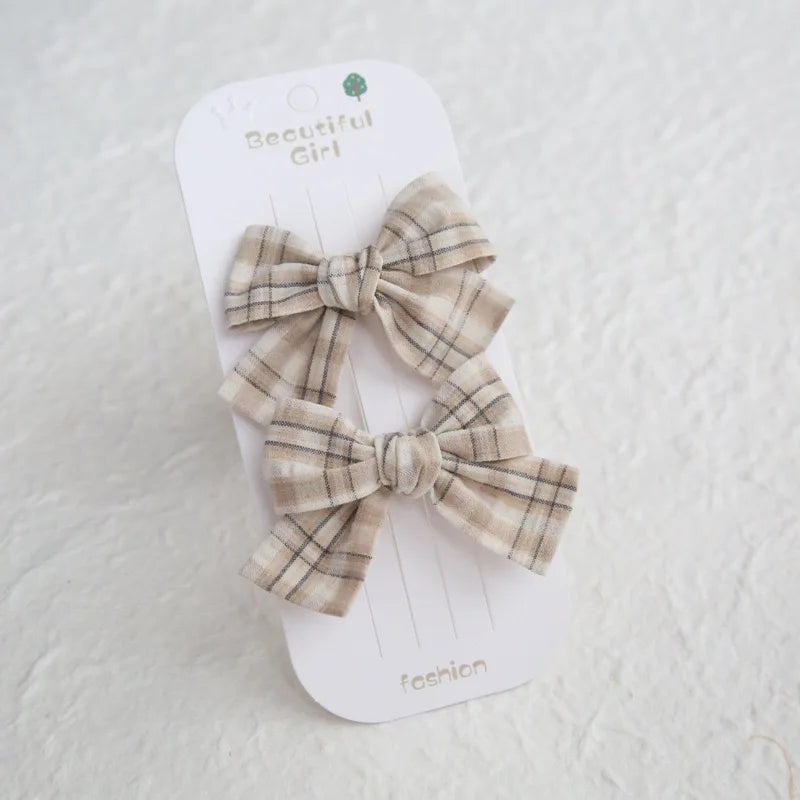 Two beige plaid cotton hair bows on clips, 7.5cm, for girls.