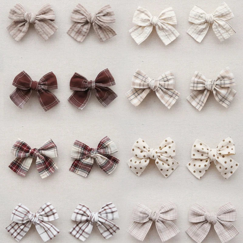 Assortment of cotton hair bows for girls in various plaid, polka dot, and solid beige patterns.