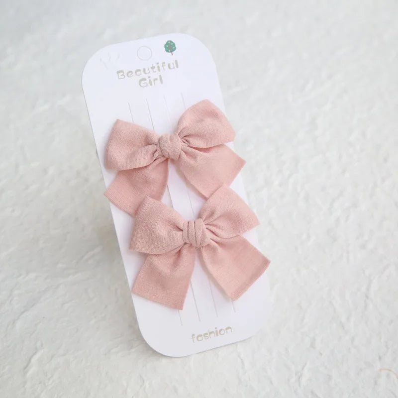 Two pink cotton hair bows on clips, 7.5cm, displayed on a "Beautiful Girl" card.