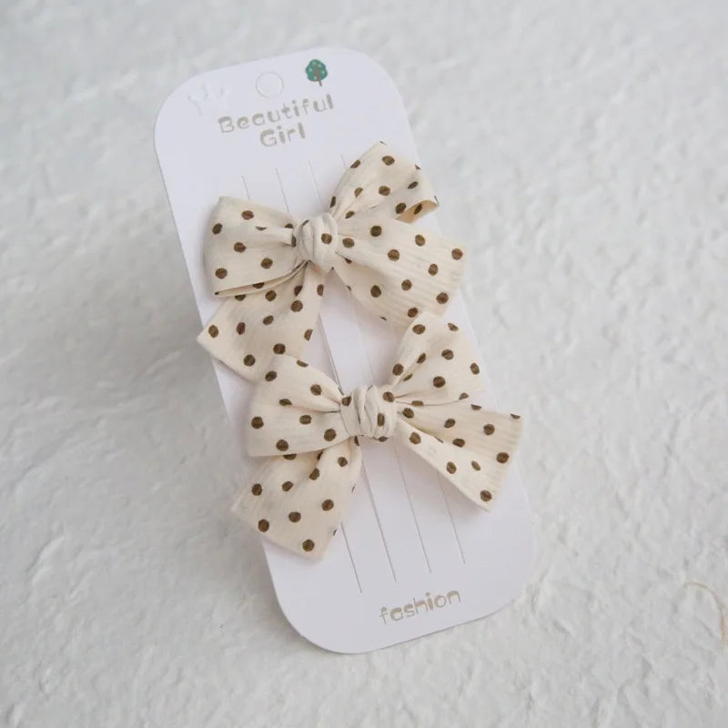 Two beige cotton hair bows with brown polka dots on a "Beautiful Girl" card.