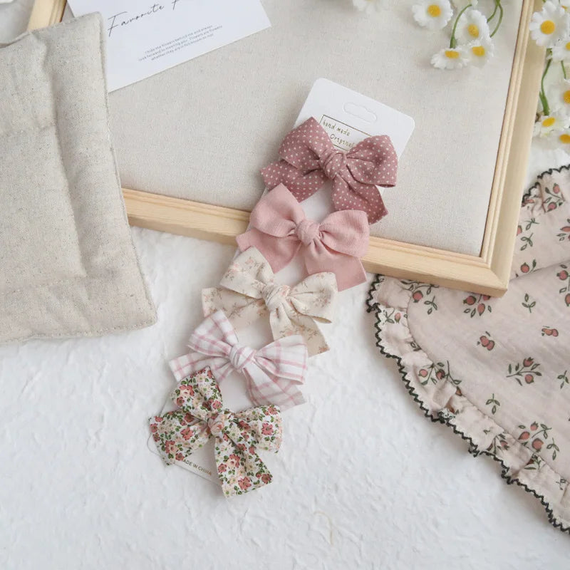 Set of five elegant cotton hair bows for girls in pink, polka dot, floral, and plaid patterns.