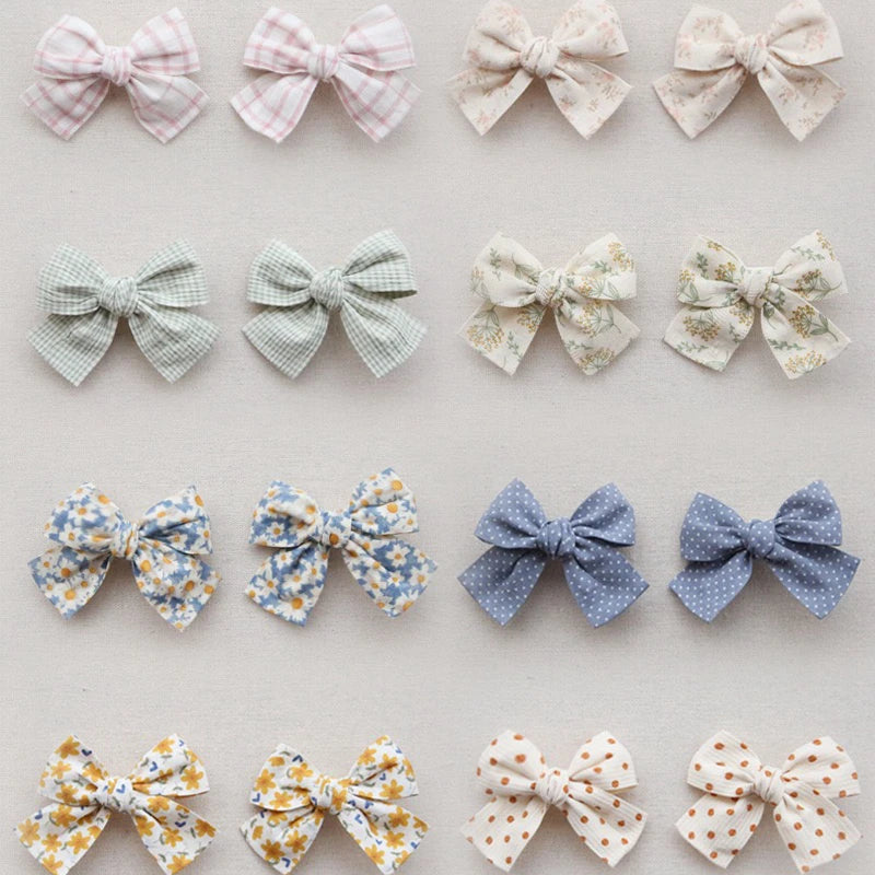 Assortment of cotton hair bows for girls in various pastel colors, patterns, and styles.