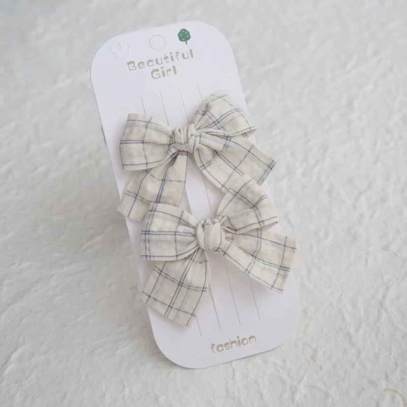 Two plaid cotton hair bows for girls, featuring a cream background with blue grid lines, on a "Beautiful Girl" card.