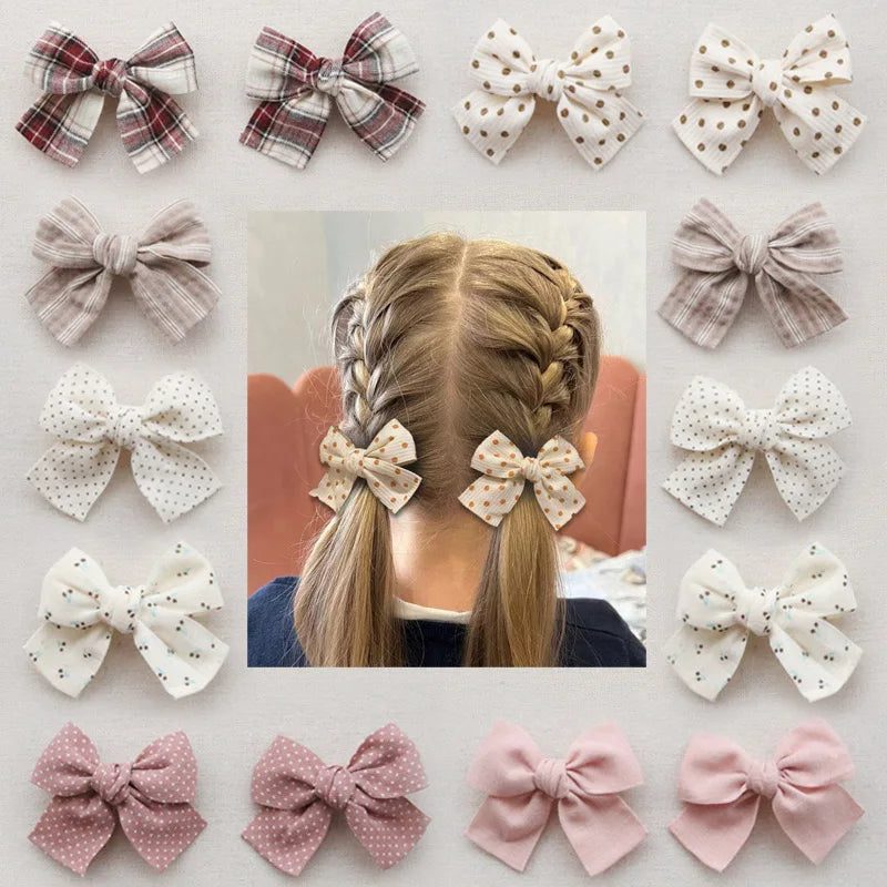 Collection of cotton hair bows in various patterns, including plaid, polka dot, and solid pink, on a child's braided hair.