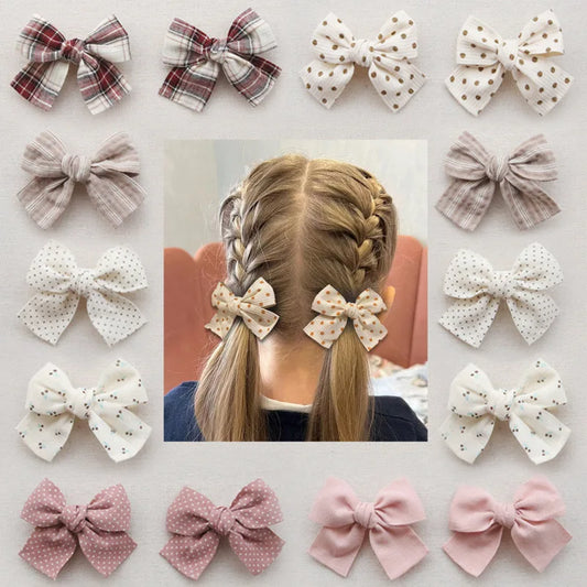 Collection of cotton hair bows in various patterns, including plaid, polka dot, and solid pink, on a child's braided hair.