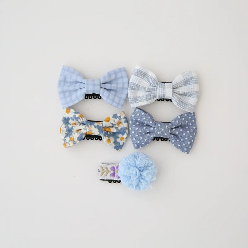 Set of five blue and white cotton baby hair clips with bows and a pom-pom.