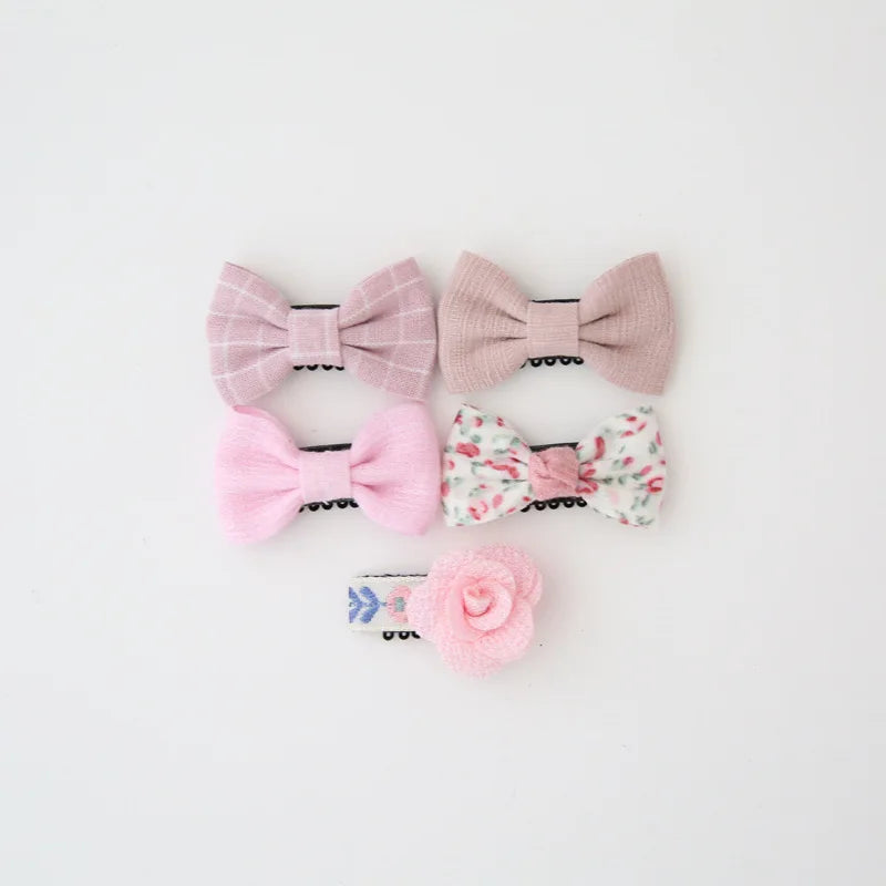 Set of five pink and floral cotton baby hair clips with decorative bows and a rose.