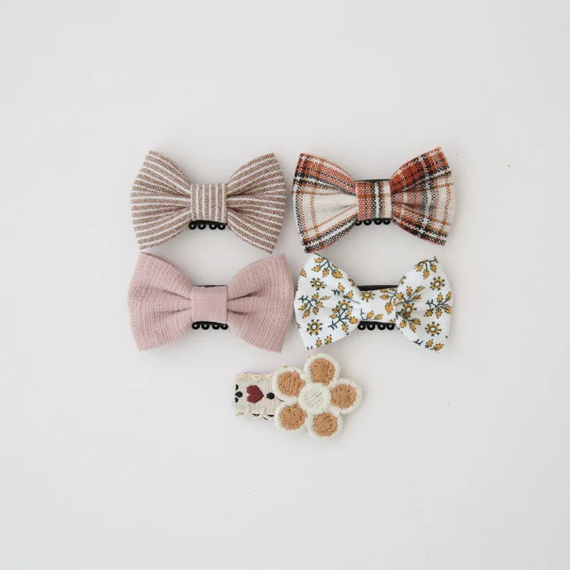 Set of five decorative baby hair clips: striped, plaid, pink, floral, and a crocheted flower.