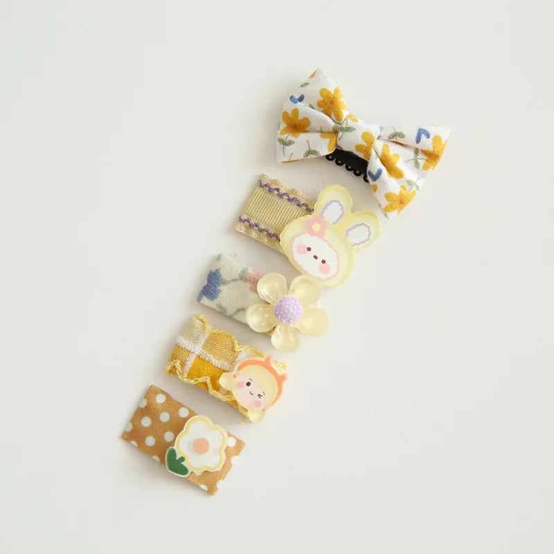 Set of five colorful baby hair clips with bows, flowers, and cute animal designs.