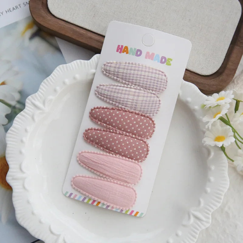 Handmade set of 6 pastel pink and lavender cotton hair clips for babies and girls.
