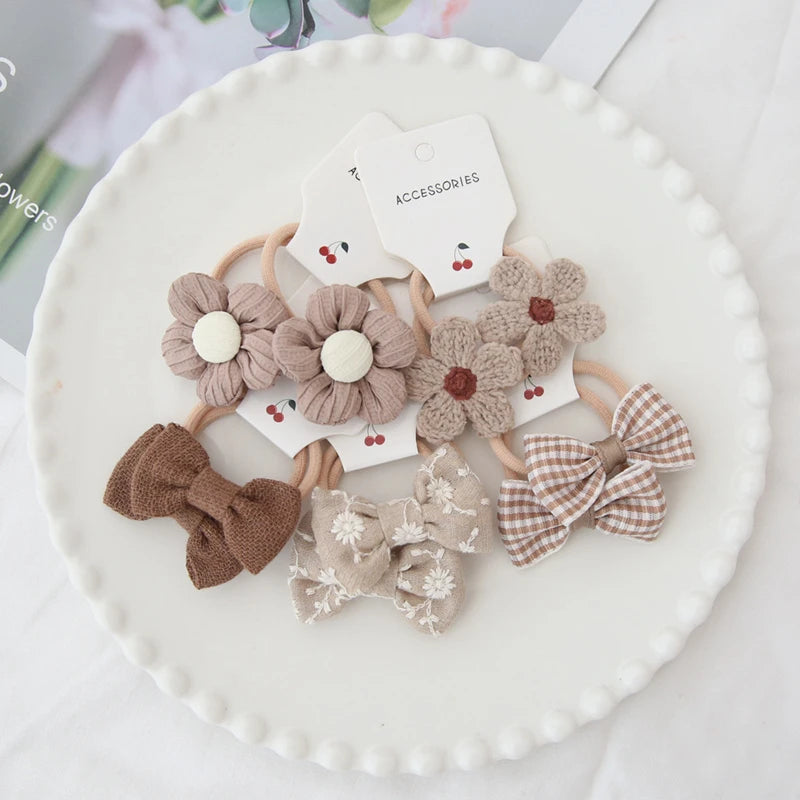 Handmade floral and bow hair ties for girls, in brown, beige, and plaid cotton.