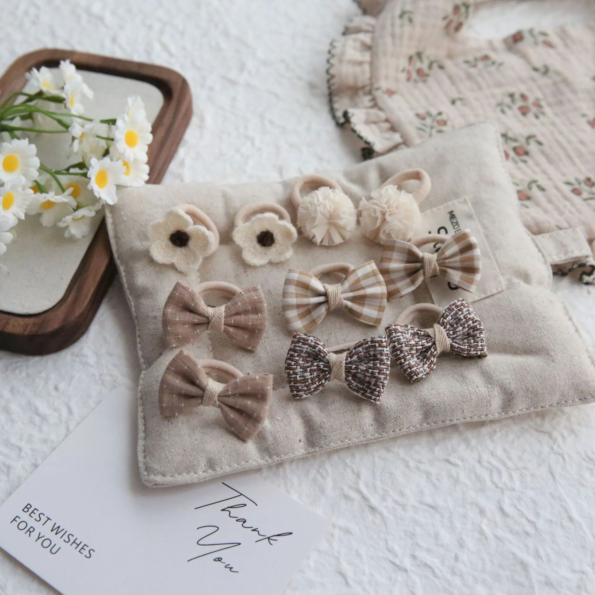 Set of 10 beige and brown cotton hair ties and clips for girls, featuring bows, flowers, and pom-poms.