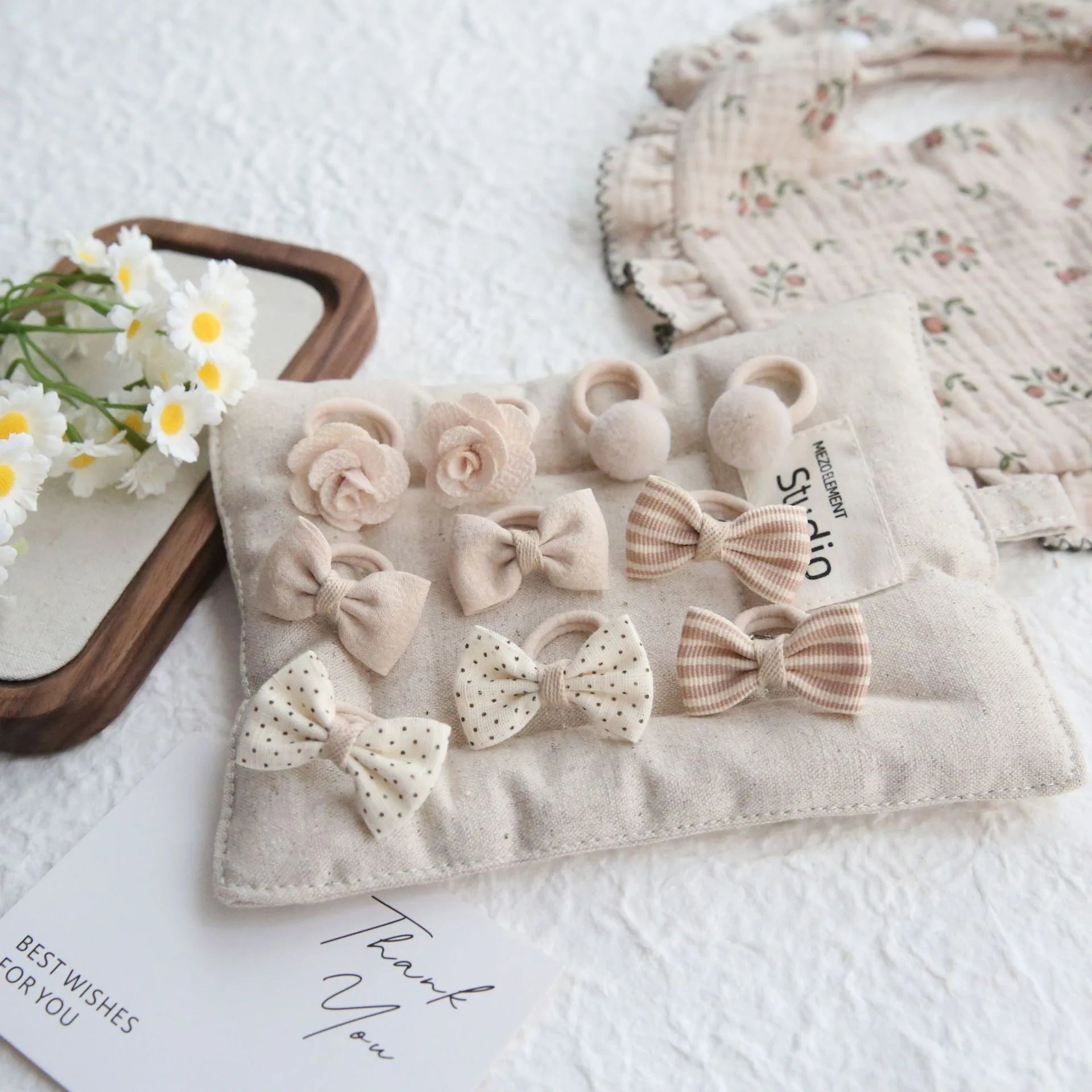 10-pack of beige cotton hair ties and clips for girls, featuring bows, flowers, and pom-poms.