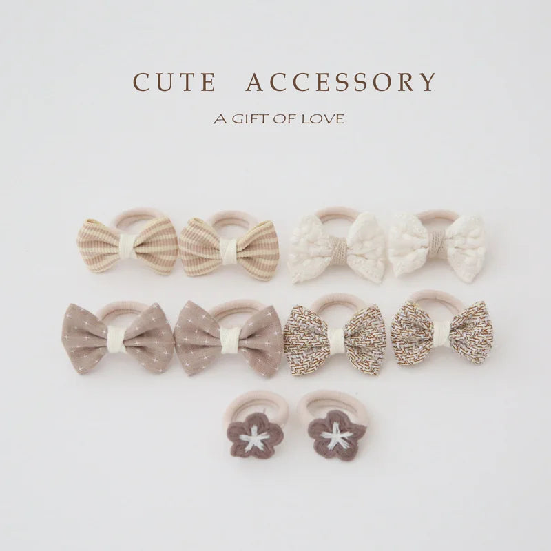 10-pack of soft cotton hair ties and clips for girls, featuring bows in beige, white, and patterned designs.