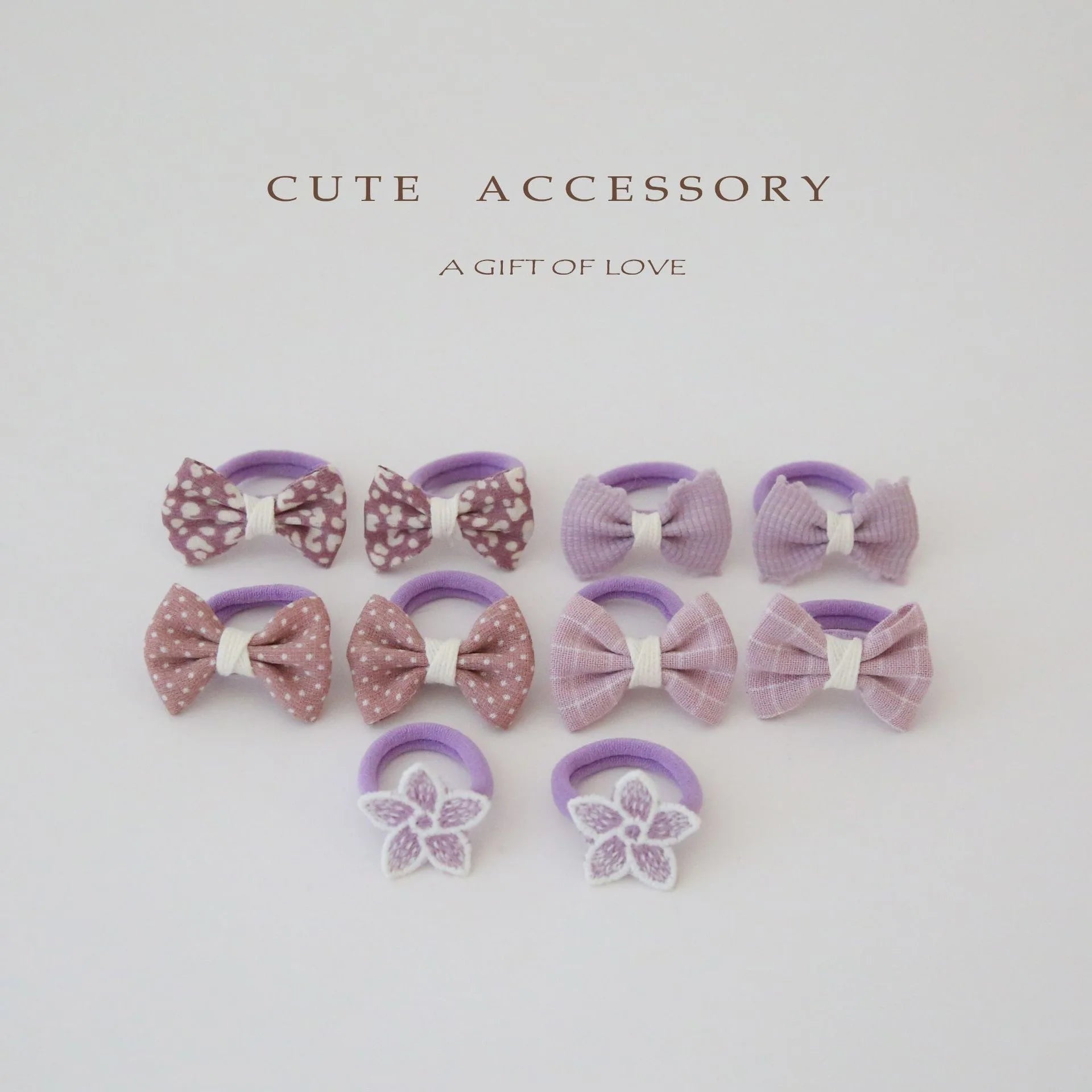 10-pack of girls' cotton hair ties and clips with purple bows, polka dots, stripes, and embroidered flowers.