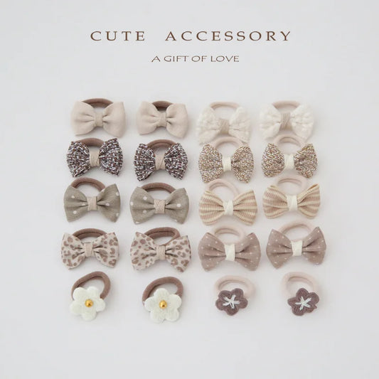 10-pack of girls' cotton hair ties and clips in various neutral colors and bow designs.