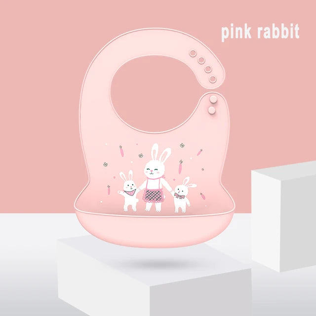 Pink silicone baby bib with adjustable neck and deep pocket, featuring a cute rabbit family design.