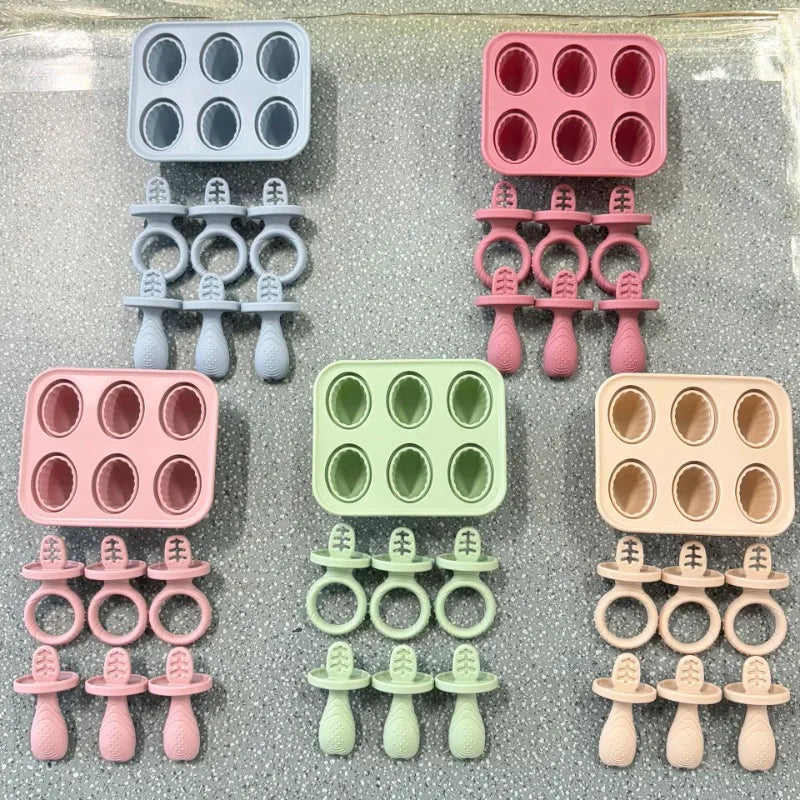 Colorful silicone baby popsicle molds with handles and teethers in blue, pink, green, and beige.