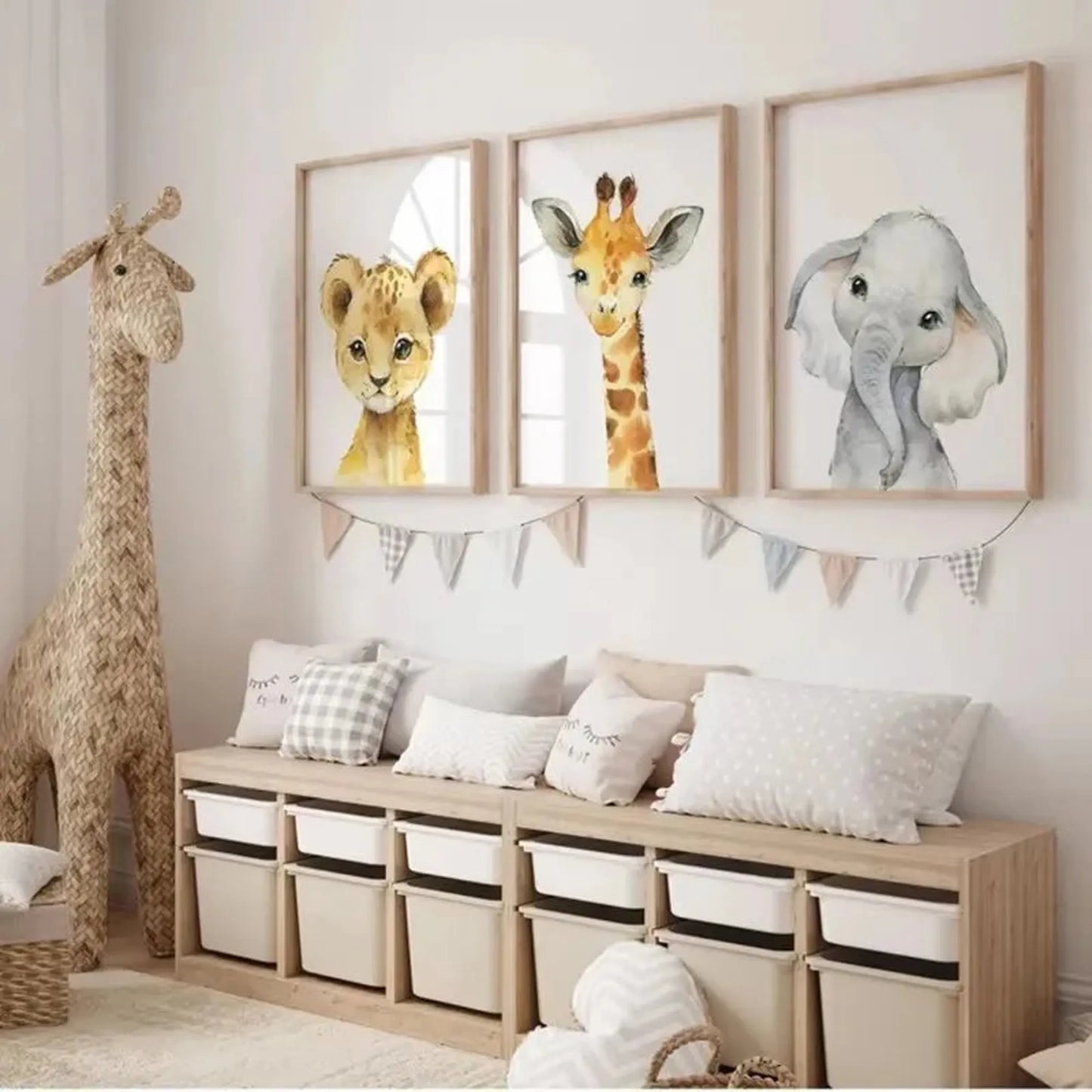 Three framed canvas prints featuring watercolor safari animals: a lion cub, giraffe, and elephant, above a wooden storage bench.