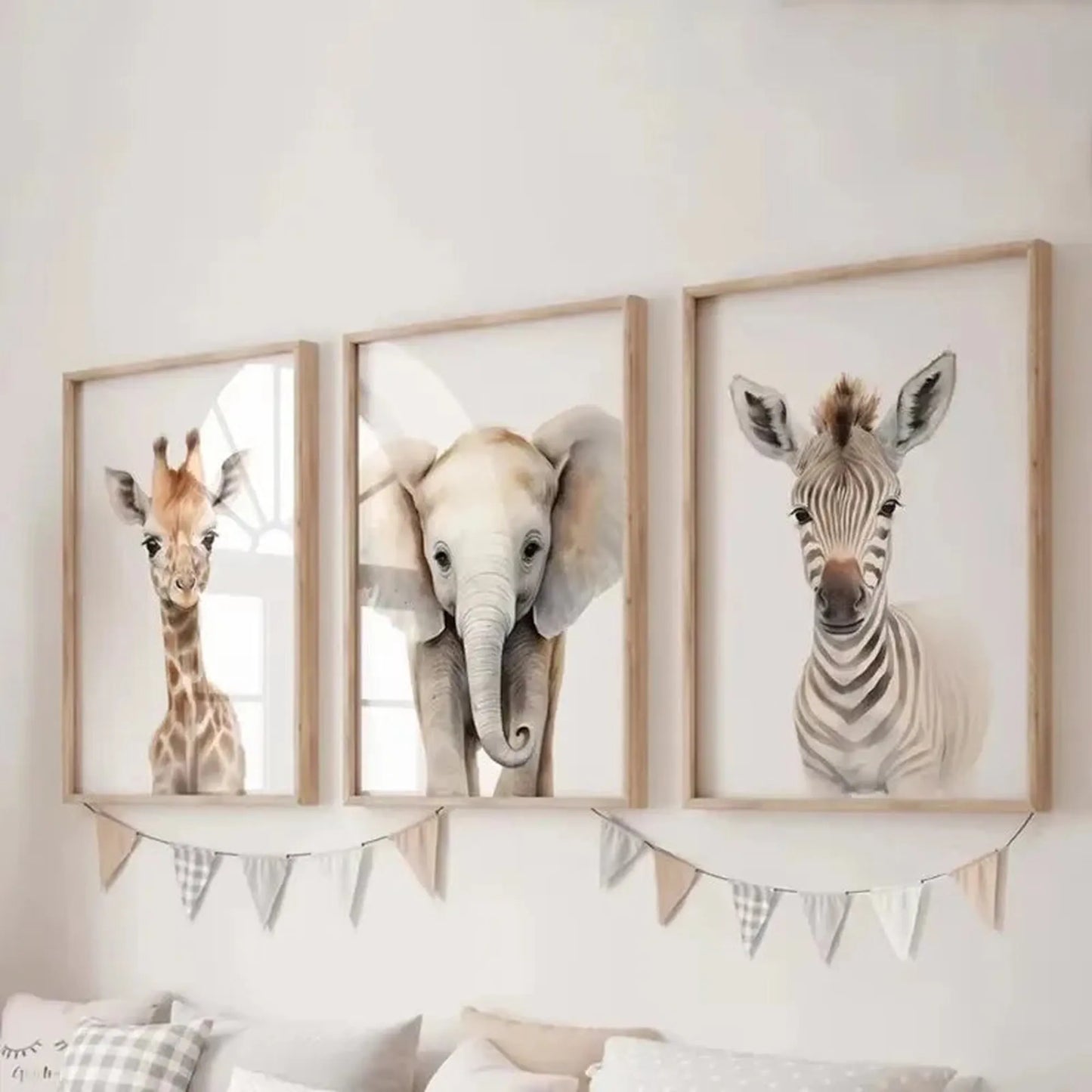 Three framed canvas prints for a nursery, featuring watercolor safari animals: a giraffe, elephant, and zebra.