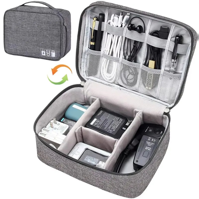 Gray Oxford fabric travel organizer for electronic cables and accessories, open with compartments.