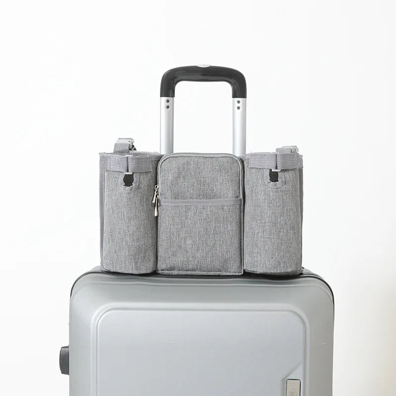Gray waterproof stroller organizer bag with multiple compartments on a silver suitcase.