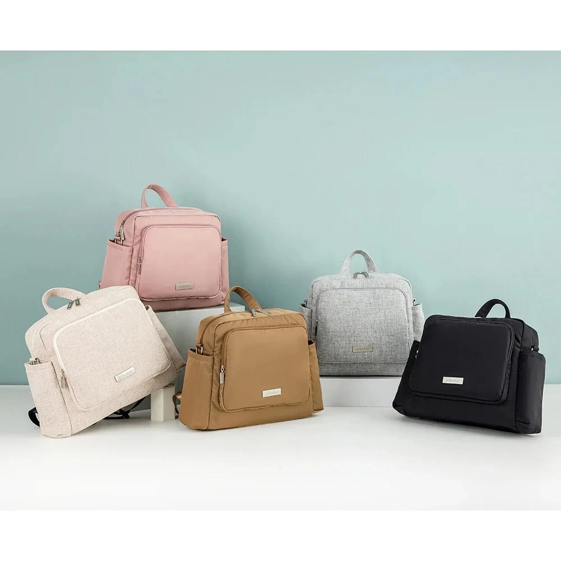 Waterproof luxury diaper backpack in black, pink, beige, tan, and gray.