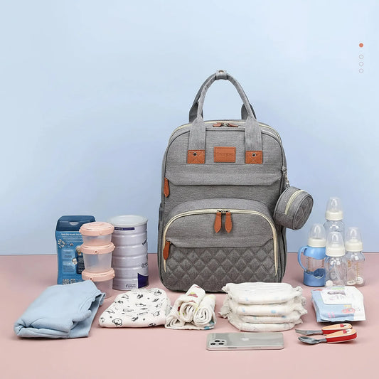 Gray 3-in-1 diaper bag backpack with quilted front pocket, brown accents, and baby essentials.