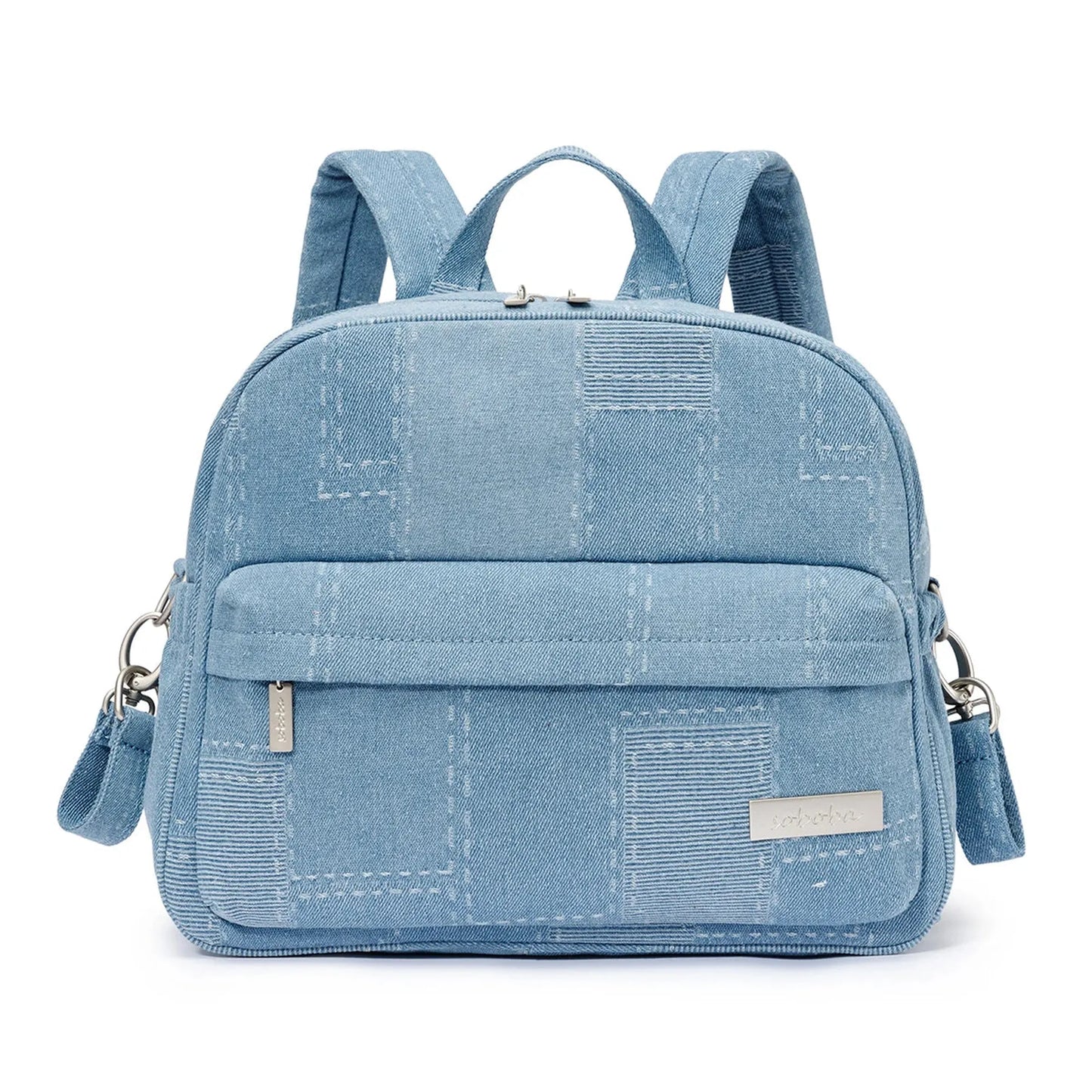 Light blue denim-style diaper backpack with patchwork pattern, front pocket, top handle, and adjustable straps.