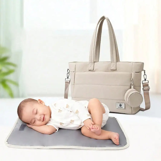 Stylish beige large-capacity diaper tote bag with a changing mat and a sleeping baby.