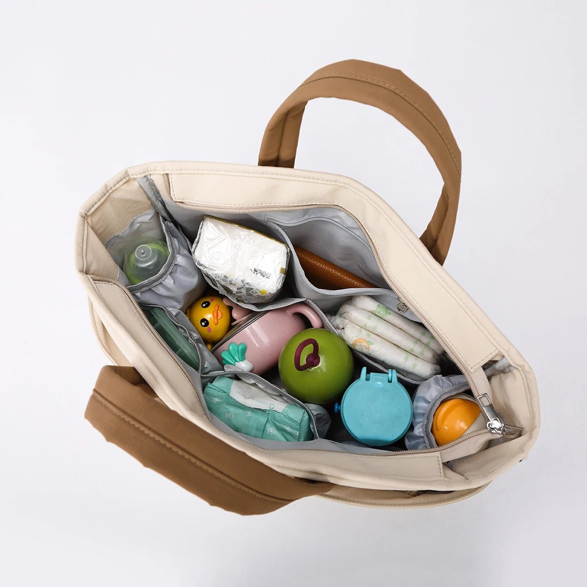 Beige insulated baby diaper bag with multiple compartments, filled with baby essentials.