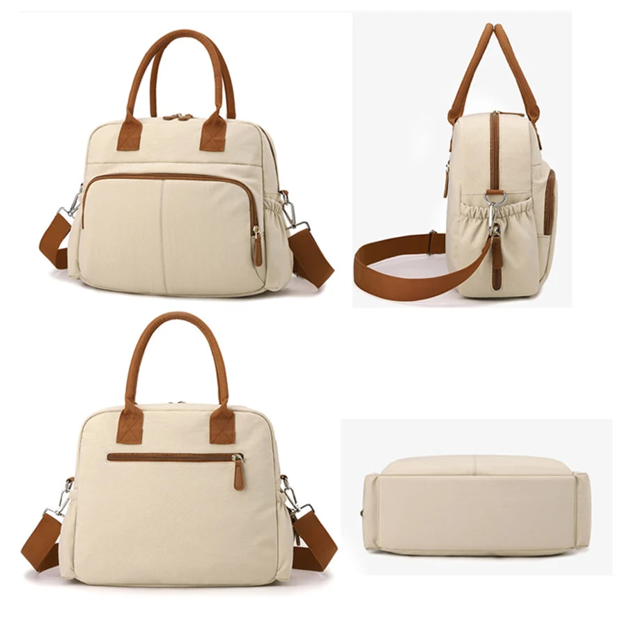 Beige diaper bag with brown trim, multiple pockets, top handles, and a detachable shoulder strap.