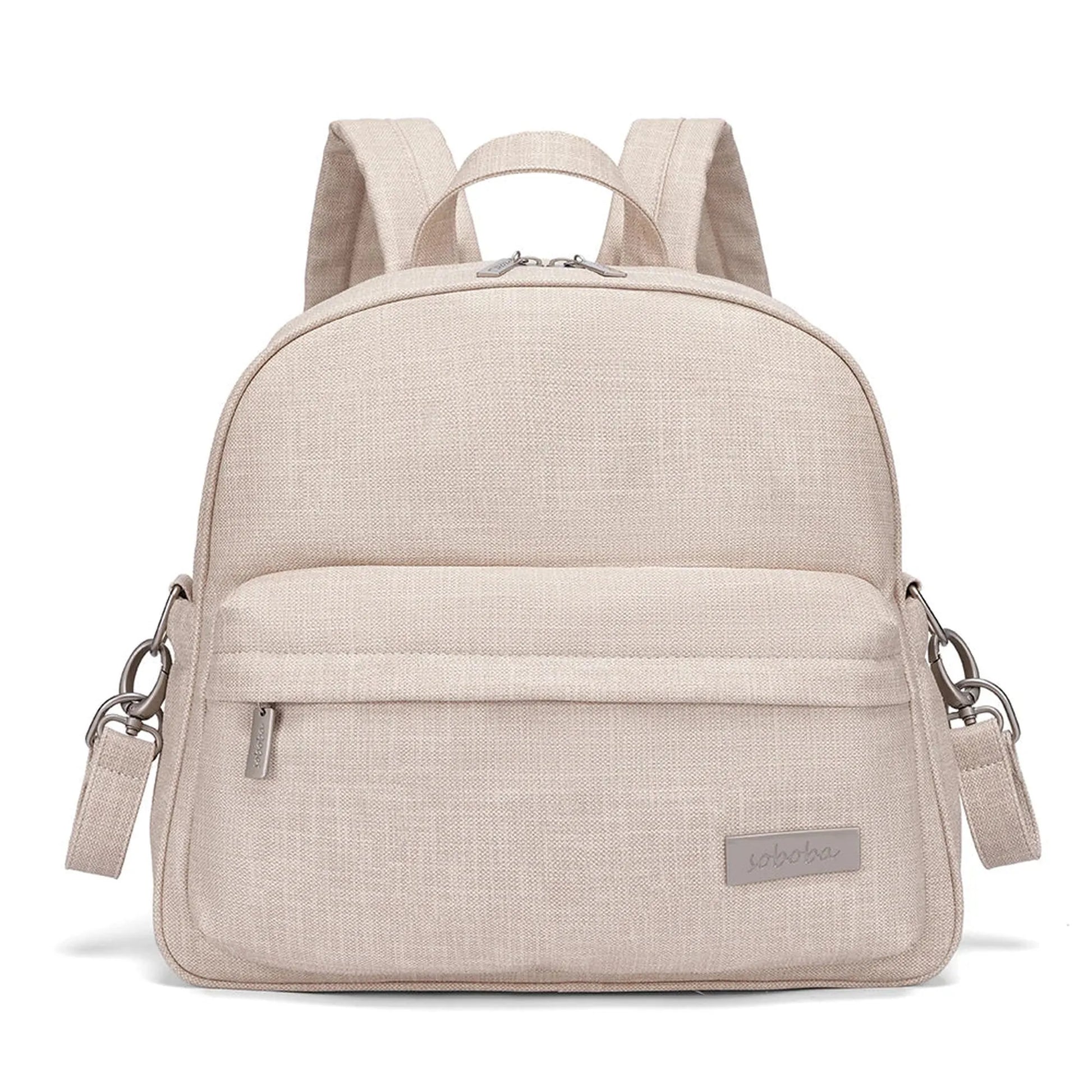 Stylish beige diaper backpack with front pocket, top zipper, and adjustable straps.