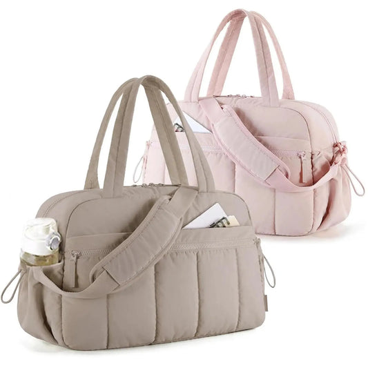 Two quilted waterproof nylon diaper bags: a beige one with a bottle in a side pocket, and a pink one in the background.
