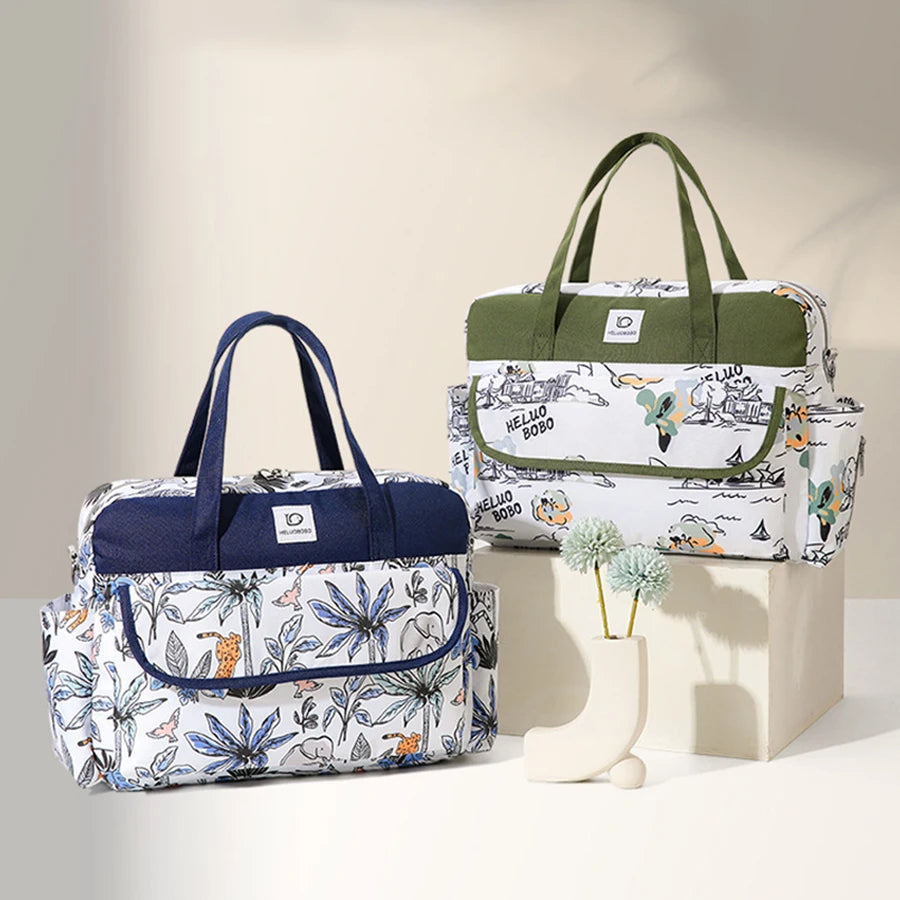 Two waterproof Oxford fabric diaper bags with nature prints; one with blue accents, the other with green.