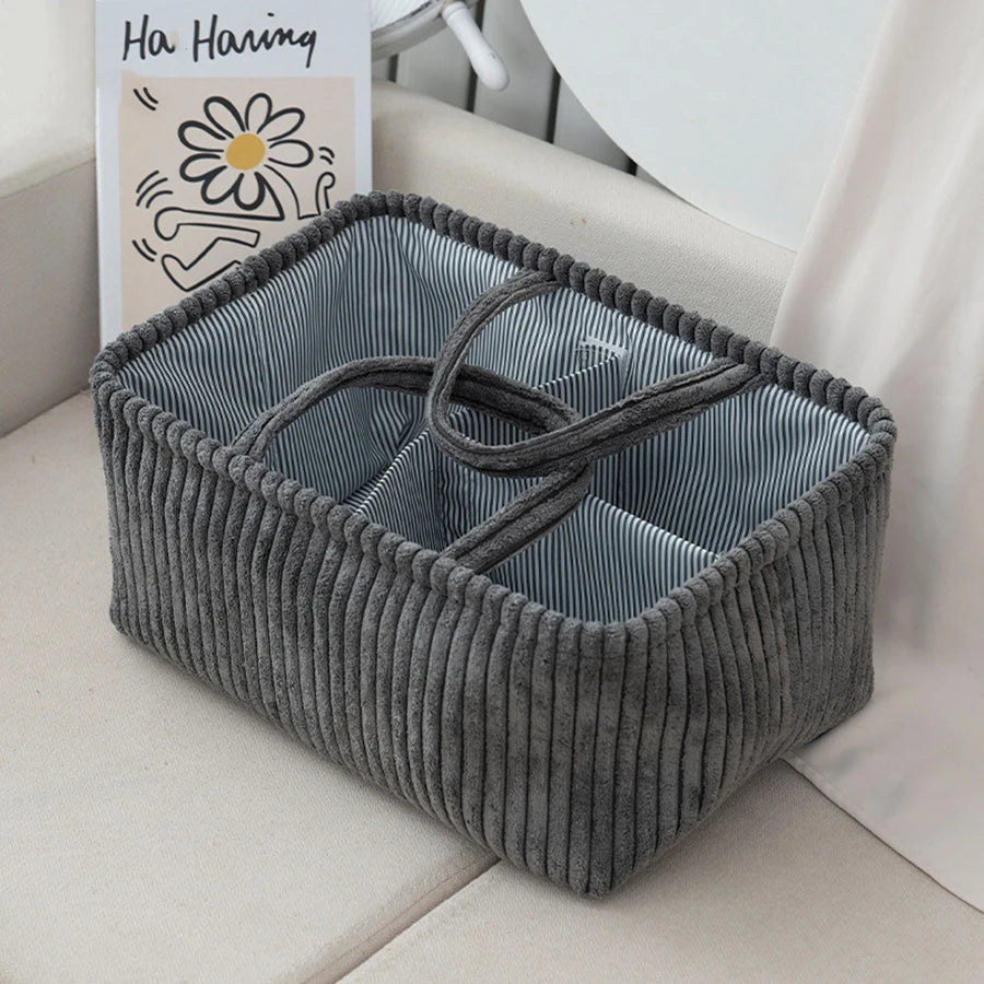 Gray corduroy diaper caddy with striped interior and multiple compartments.