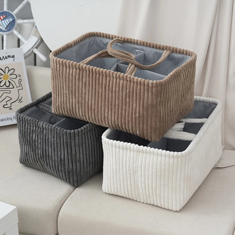Corduroy diaper caddy in brown, gray, and white with striped lining and handles for baby organization.