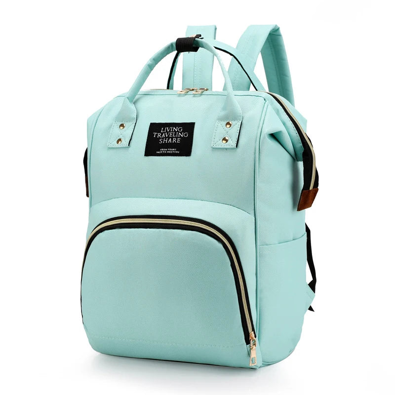 Light blue canvas diaper backpack with thermal pocket, top handles, and front zipper.