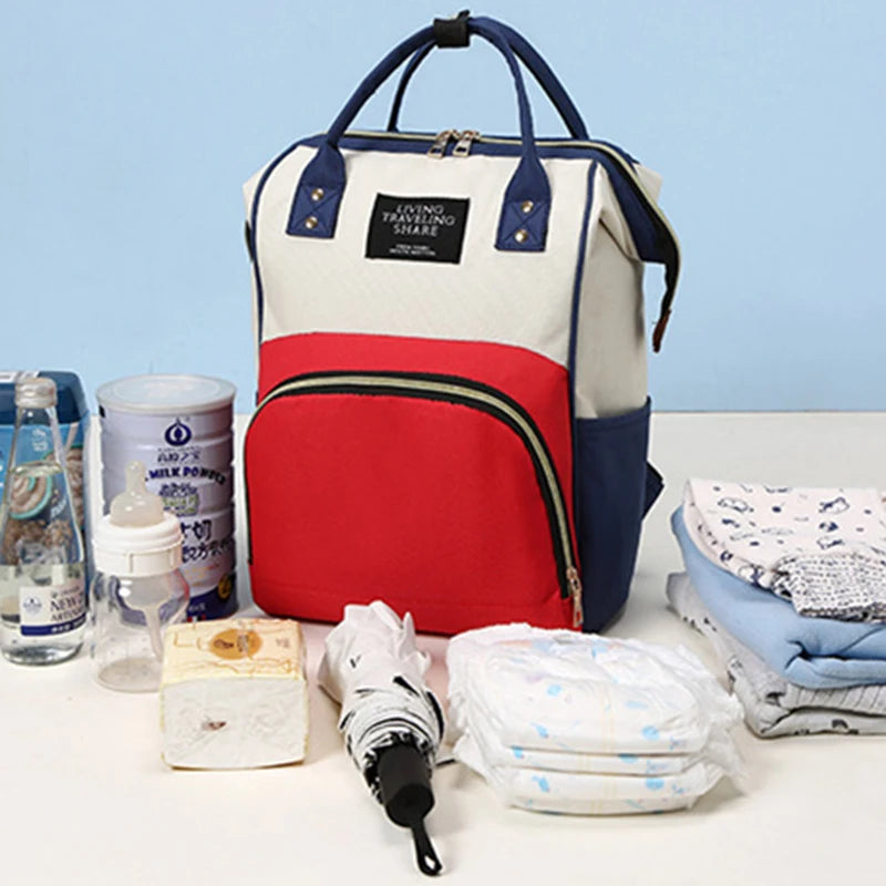Multifunctional canvas diaper backpack in cream, red, and navy with thermal pocket.